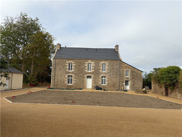 Cour aménagée devant une maison en pierre