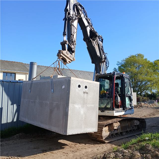 Mise en place d’une cuve en béton avec une pelle mécanique