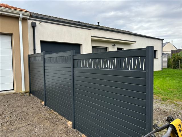 Clôture grise posée devant une maison