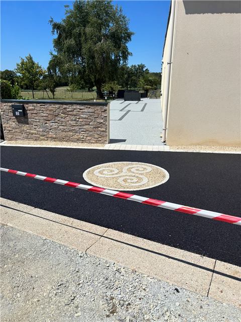 Cour en enrobé avec motif triskell et bordure claire